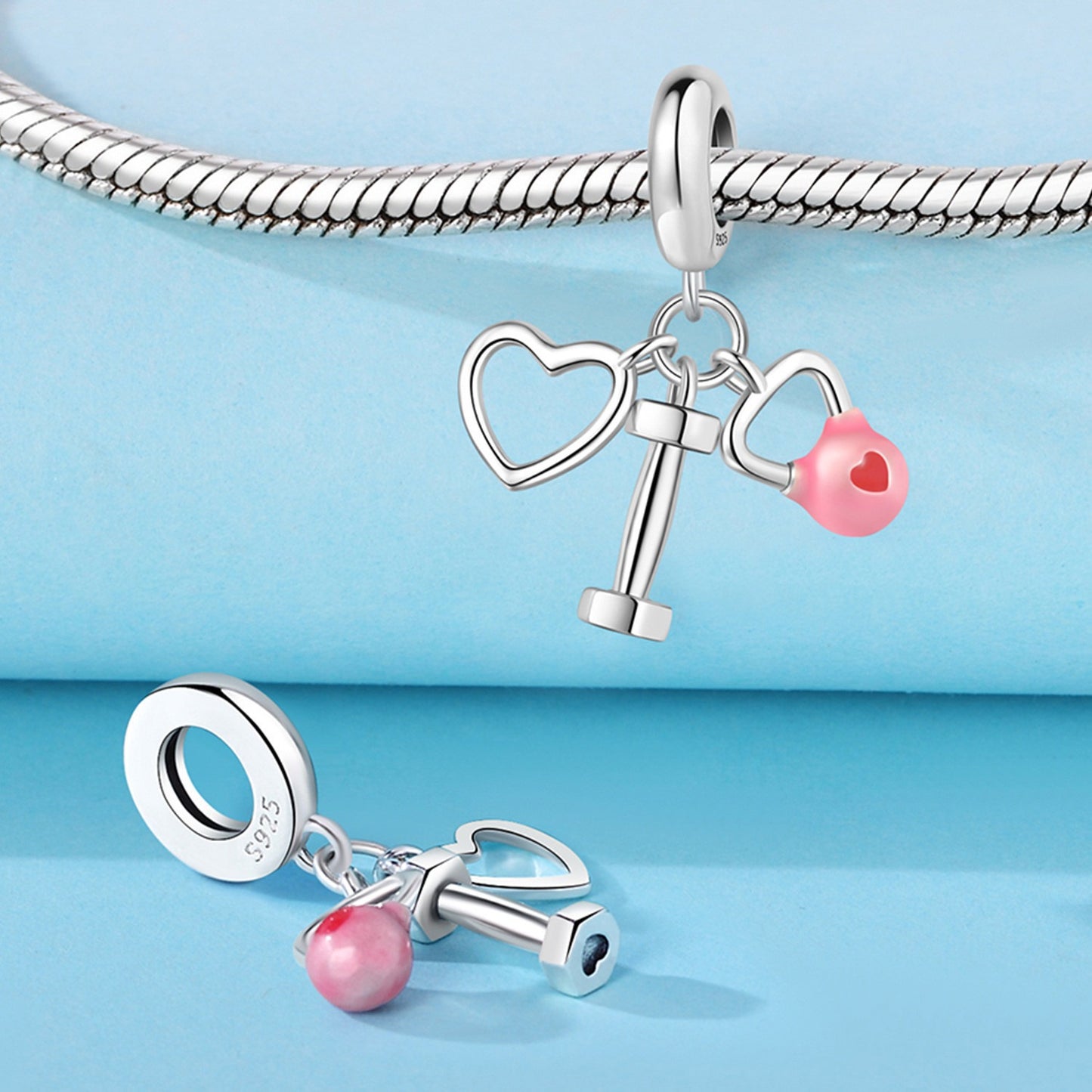 berloque coração com haltere e kettlebell